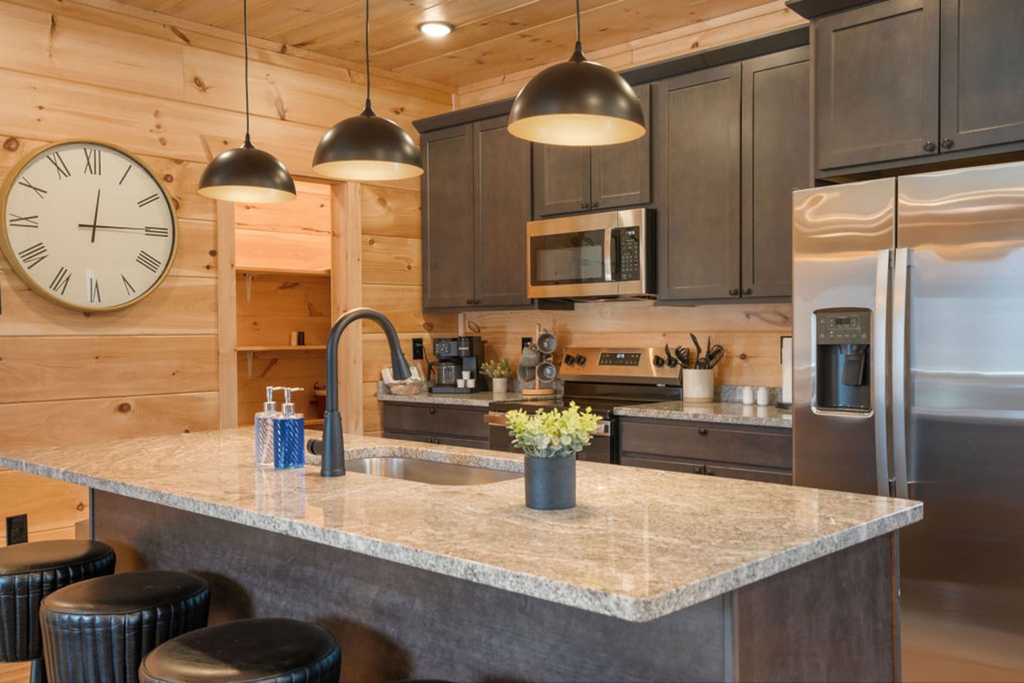 Fully equipped kitchen with island seating and pine cabin walls